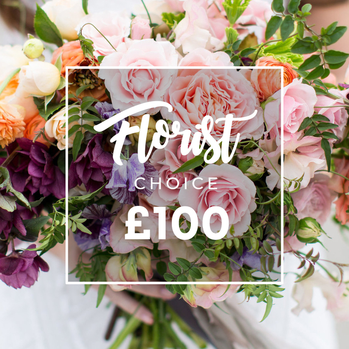 Framed in soft focus and held gently at the base, this hand-tied bouquet feels like an intimate garden moment: multiple large, full pink garden roses with ruffled petals form the focal cluster, their soft blush tones complemented by peach and coral ranunculus-like blooms that add warmth and a layered, sculptural quality. Darker plum or burgundy hellebore-style flowers nestle beneath and between the roses, providing rich contrast, while pale purple-and-white sweet peas with their delicate, almost striped markings trail through the arrangement, lending airiness and movement. Creamy white accents and sprigs of mixed green foliage - from long, slender tendrils to broader matte leaves - weave around the blooms to create depth, texture and a natural, garden-style silhouette. Superimposed centrally is a clear white rectangular label: the flowing script reads Florist Choice, with CHOICE in smaller block letters beneath and a prominent ?100 displayed in bold, modern numerals at the bottom, all enclosed by a thin white square border that makes the offering obvious without obscuring the flowers. The bouquet is held by hands in front of a softly blurred, light backdrop, the gesture communicating thoughtful presentation and human touch. This arrangement exudes quiet romance and artisanal quality - a perfect florist-picked option for weddings, heartfelt thank-you gifts or marking special moments - and it would sit comfortably among the seasonal displays you might see near the Radcliffe Camera or the quiet lanes off High Street in Oxford.