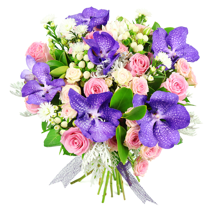 This hand-crafted bouquet, shown clearly against a bright white backdrop, showcases the skill of an experienced Oxford florist who understands both colour and balance. The eye is first drawn to the striking Vanda orchids, whose large, broad petals are saturated in rich purple tones, patterned with intricate speckling in indigo and violet that gives each bloom a unique, almost mosaic-like appearance. They rise slightly above the rest of the flowers, adding a vertical rhythm and focal drama. Around them, soft pink roses unfold in varied stages of bloom, from tightly held buds that promise future beauty to fully opened roses with generous, layered petals conveying classic romance. Intermingled among these are clusters of creamy white spray roses, their smaller blooms forming delicate groups that soften the transition between the bolder orchids and roses. Fine sprays of tiny white filler flowers weave through the design, adding movement and a light, airy quality, while plump, waxy white or cream hypericum berries provide rounded shapes that contrast with the petals' softness. Silvery-grey dusty miller foliage, with its gently frilled, velvety leaves, introduces a cool, frosted tone that pairs beautifully with the orchid's purples and the pastel roses. Rich, glossy green leaves support and frame the entire arrangement, giving it a lush fullness and neat structure. The stems are wrapped tightly in a semi-sheer silver-purple ribbon, its subtle shimmer and trailing ends completing the design with a contemporary flourish. The bouquet feels suited to the refined character of Oxford, as if destined for a college celebration, an intimate anniversary dinner near Jericho, or a special birthday surprise sent across the city, expressing admiration, appreciation, and timeless elegance.