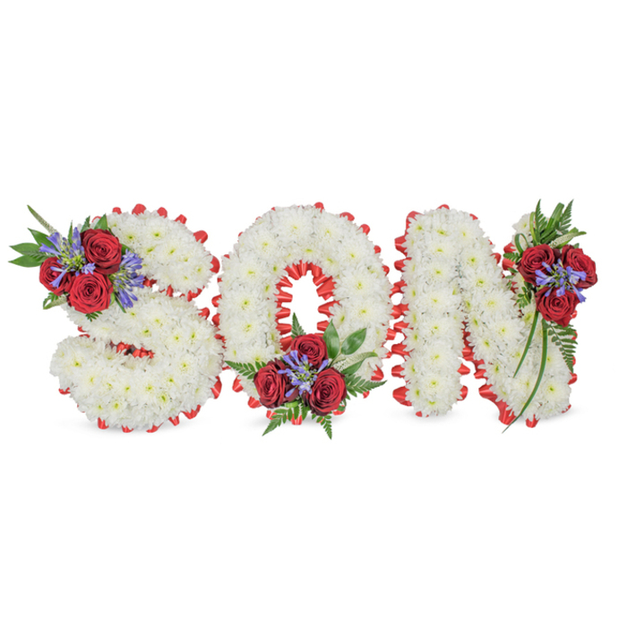 A poignant, carefully finished floral tribute arranges the letters SON in a clean horizontal layout, each letter built from tightly clustered white chrysanthemums that form a soft, clouded surface. Against the bright white background, the chrysanthemum blooms create a uniform, gently rounded texture that reads as calm and pure. Surrounding each letter a scalloped belt of red satin ribbon has been hand-folded and applied, the glossy trim throwing a warm red rim around the white while crisply defining the S, O and N shapes. Tastefully placed accent bouquets enliven the composition: the S is graced at its upper-left curve, the O receives a cluster low in its inner curve, and the N bears an arrangement on its upper right. Each accent includes a trio of deep red roses, upright spires of blue-purple Liatris and abundant dark green foliage with fern fronds and trailing leaves, adding vertical contrast and a hint of movement. The implied scent is a restrained mix of rose perfume and fresh greenery, the tactile impression one of softness against satin. Intended as a bespoke funeral tribute for a son, the colours and craftsmanship convey purity, reverence and enduring affection. This is the kind of memorial piece a seasoned Oxford florist might deliver to chapels around St Giles or to a graveside by Magdalen Bridge, offered with careful handling and respect for the family's wishes.