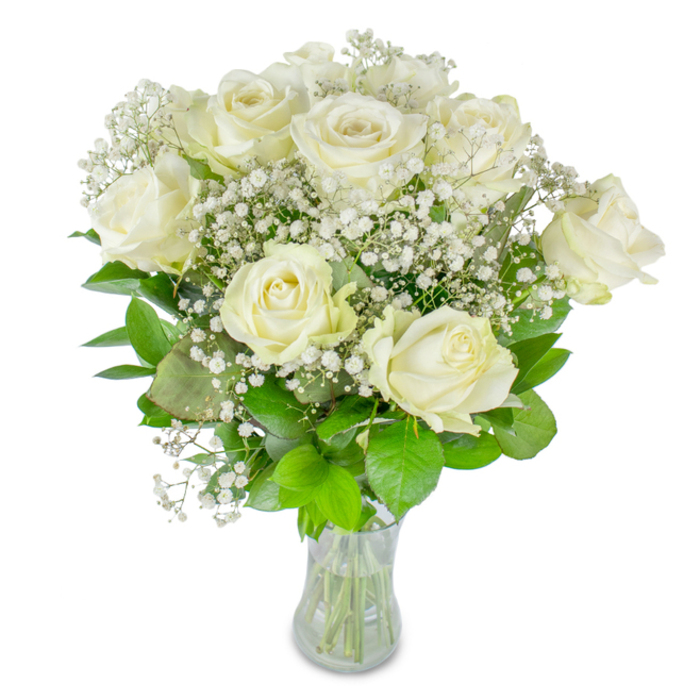 This composition reads as an ode to serene refinement: a cluster of white roses, their creamy petals layered and luminous, is embraced by an ethereal veil of baby's breath, all held within a modest, transparent glass vase. The roses vary from fully unfurled blossoms-velvety and open, revealing soft, concentric petals-to those still gently cupped, suggesting promise and continuity. The baby's breath acts like a soft-focus filter, its myriad tiny blooms creating an almost lace-like texture that softens the silhouette and lends romantic lightness to the arrangement. Lush greenery-leaves of deep, satiny green and paler, crisp shoots-frames the flowers and anchors the bouquet with natural energy, offering a vivid contrast that amplifies the whites' clarity. Neatly trimmed stems are visible through the vase, and the clear waterline speaks to attentive preparation and immediacy. The lighting is muted and flattering, catching the subtle translucence at the petal edges and casting gentle shadows that enhance depth. To touch, the petals appear tender and slightly cool, while the gypsophila feels papery and fragile, a textural counterpoint to the roses' plushness. The overall mood is one of peaceful celebration or hushed reverence-appropriate for weddings, anniversaries, or moments of remembrance-conveying purity, steadiness, and a timeless sense of care. For a florist laying out arrangements for intimate ceremonies or quiet home displays, this bouquet is a study in balance: delicate yet rooted, luminous without extravagance.