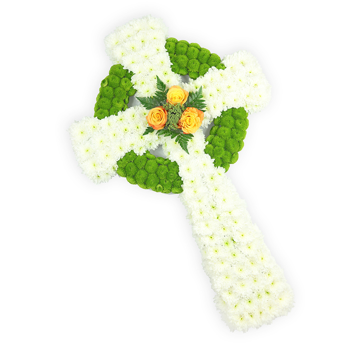 A sculpted floral Celtic cross sits plainly against a bright white studio background, its form defined by the meticulous placement of fresh flowers and considered florist technique. The dominant surface is a dense carpet of small white spray chrysanthemums that produce a gentle, almost cloud-like texture across the arms and elongated shaft; each tiny petal catches the light softly, conveying quiet purity. Accenting the white are vivid apple-green button chrysanthemums, carefully set to outline the circular ring where the cross's arms intersect and to fill alternating panels along the horizontal arms - their compact, rounded heads create plush contrast and a rhythmic pattern across the piece. At the very heart of the cross, a compact cluster of three warm orange-yellow roses provides a luminous focal point; their velveteen petals fold into one another, radiating a subtle glow that lifts the cooler tones around them. A few sprigs of deep green foliage, reminiscent of fern fronds, cradle the roses and add a natural, sculptural frame. The colour scheme - white, green and orange - inevitably suggests a respectful nod to Irish heritage, making this arrangement a thoughtful choice for memorials or services honouring Irish roots. Soft studio lighting emphasises the cross's three-dimensional presence and the gentle contrast between bloom textures. Crafted with the quiet care of a neighbourhood florist serving families across Oxford - from Botley Road to St Giles and the Radcliffe Camera - this piece would be chosen to convey heartfelt sympathy and measured reverence; Flowers Oxford prepares similar tributes with attention to proportion and seasonality for local delivery.