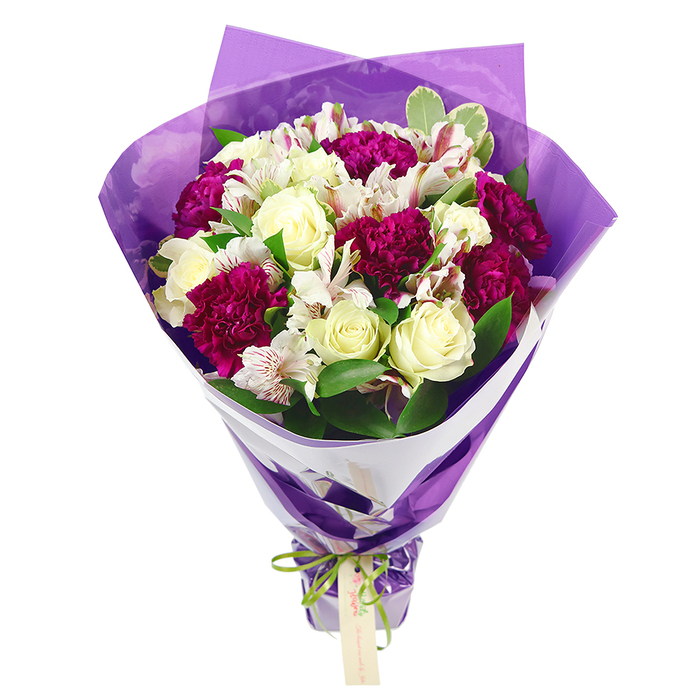 Set against a simple white background, this elegant hand-tied bouquet appears as if it could be resting on a wooden table in a cosy Oxford florist just off Cowley Road. The arrangement is dominated by soft white roses, their petals unfurling in tight, layered spirals that hint at gentle fragrance and timeless romance. Interlaced with these are deep magenta carnations, their rich, ruffled blooms bringing a vibrant contrast, like splashes of berry colour against snow. Scattered between the larger flowers are stems of white alstroemeria, or Peruvian lilies, with slim petals delicately streaked with pinkish-red lines and centred with dark stamens, adding a fine, almost painterly detail to the mix. Around the blooms, lush green foliage provides structure and freshness; some leaves are solid, glossy green, while others feature subtle variegation along the edges, giving the bouquet extra texture and movement, reminiscent of tree-lined paths through University Parks. The flowers are gathered closely to form a rounded, full crown of colour and form, then drawn down into a sleek bundle of stems. Wrapping the stems is an inner collar of crisp white paper, folding neatly to frame the heads of the flowers and create a clean visual boundary. Over this, a sheer purple cellophane layer is loosely draped and gently crinkled, catching the light and adding a sense of celebration and modern flair. At the very base, a bright lime-green satin ribbon ties the stems together, its bow sitting snugly, with an understated, light brown rectangular gift tag suspended beneath, ready for a handwritten note. The bouquet feels joyful yet thoughtfully composed, perfect for marking graduations, thank-you gestures, or quiet celebrations across Oxford.