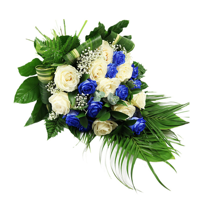 A luxurious cascading funeral spray of blue and white roses lies against a crisp white backdrop, its composition flowing from a fuller upper-left section down to a tapered, graceful point at the lower right. The arrangement is dense with roses, each flower fully open and soft-looking, their layered petals inviting the eye to linger. Creamy white and ivory blooms sit shoulder to shoulder with roses in a vivid sapphire blue, the kind of rich tone that instantly catches attention yet still feels calm and respectful. This alternating pattern of pale and dark creates a striking contrast, similar to the interplay of stone and sky along Oxford's historic High Street on a clear day. Between the roses, fine clusters of white baby's breath scatter like tiny stars, lending a clouded, misty delicacy that lightens the whole design. Around this central river of blooms, the greenery forms a strong yet elegant frame: glossy, broad leaves build a deep green backdrop, while feathery ferns splay upwards and outwards at the top, giving a sense of lift and life. From the base, long palm fronds sweep downward and slightly outward, defining the familiar teardrop silhouette often used for memorial tributes at Oxford crematoria and church services. Here and there, sprigs of silvery-blue-green foliage, reminiscent of eucalyptus, introduce a softer, more muted green and a different leaf shape, adding visual interest. Strips of broad green leaves are folded and wrapped into ornamental bands that weave across the spray, reflecting the skill and refinement of an experienced florist. The overall feeling is one of composed sorrow and gentle comfort, a dignified sympathy spray that would look at home beside a coffin or memorial frame in an Oxford chapel of rest.