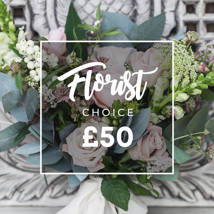 A richly composed, hand-tied bouquet sits before a gently blurred backdrop of pale carved stonework, evoking an elegant Oxford interior such as a college hall or a Georgian townhouse on High Street. The arrangement centres on abundant soft blush-pink roses whose unfurling petals create a romantic, full-bodied focal point; around them, abundant dusty blue-green eucalyptus leaves with rounded shapes offer a cool, matte contrast. Interspersed among the foliage are bright white berries - likely snowberries or hypericum - that bring crisp, spherical highlights and a touch of seasonal brightness. Fine sprays of white filler flowers, perhaps waxflower or astrantia, create an airy, natural veil and tie the composition together, while small deeper pink or burgundy blooms add depth in the shadowed recesses. At the left and right edges slender, upright green-and-white spikes reminiscent of snapdragons introduce vertical energy and architectural form. The stems are neatly bound with a soft cream fabric ribbon, knotted to reveal the tactile, handcrafted quality of a florist's tie. Overlaying the image is a clean white rectangle carrying the words Florist in a flowing script and CHOICE beneath it, with a bold ?50 price - a clear visual cue that this is the florist's curated option, assembled from the freshest seasonal ingredients. Soft daylight gives the whole bouquet a luminous, matte finish, making the blossoms appear both soothing and enlivening. The picture reads as a promise of craftsmanship and freshness and would suit a thoughtful gift, a small wedding table, or a polished housewarming present delivered locally across Oxford.
