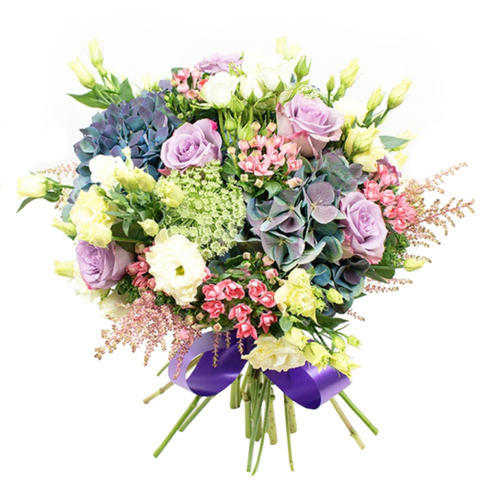 Brimming with artistry and fresh fragrance, this exquisite hand-tied bouquet from central Oxford features a lavish medley of hydrangeas, roses, ranunculus, and textured fillers. Large, multi-petaled hydrangea heads in indigo, teal, and a hint of moody purple form the visual core, their fullness echoing the grandeur of the city's historic colleges. Interwoven among them are lush roses-some delicately lilac, others serene white-each bloom perfectly unfurled and velvety to the touch. White ranunculus layers its petals in tight, cloud-like clusters, softening the bouquet with a creamy opulence. Slender yellow-green eustoma (lisianthus) stems rise here and there, mingling youthful buds and freshly opened blossoms, subtly evoking the renewal of Oxford Botanic Garden in early spring. Filler flowers-dainty fuchsia sprays and pillowy pink astilbe-add lively colour and whimsical silhouette to the composition, while fine, lacy umbels in pale green and white create intricate detail and refined structure. All around, rich dark foliage fills the spaces, allowing each flower's character to shine. The bouquet is skillfully bundled, its stems bound by a gleaming satin ribbon in deep royal purple-a touch that's traditional yet contemporary, much like Oxford itself. Ideal for birthdays, anniversaries, or simply celebrating a cherished moment, this bouquet brings the artistry of local floral design to your door, promising both visual delight and heartfelt sentiment.