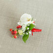 A close-up, slightly overhead view of a handcrafted floral boutonniere resting on a softly textured, oatmeal-coloured linen fabric, the kind of natural backdrop you might see on a rustic table in an Oxford college hall. At the heart of the piece sits a single white Phalaenopsis orchid bloom, its broad petals smooth and porcelain-like, gently curving outward to reveal a warm throat washed with creamy yellow and soft orange tones. Around the orchid, clouds of delicate white baby's breath cluster in tiny, starry florets, creating a light, airy halo that contrasts with the orchid's bold, sculptural form. Nestled beside the flowers is a neat spray of glossy, round red berries, their rich, cherry hue suggesting winter weddings or festive celebrations near Oxford's historic High Street. A few paler green, oval buds peek out between the berries, adding a sense of freshness and new growth. Lush green foliage, in both broader and more slender shapes, is threaded throughout the design, framing the white blooms and berries with a calm, verdant backdrop. The stems are tightly bound with a vibrant red satin ribbon, its sheen catching the light as it wraps smoothly around the base and finishes in a small, tidy knot with short tails that sit flush against the fabric. The natural linen beneath provides an understated, neutral stage, allowing the crisp white orchid, feathery gypsophila, and jewel-like berries to stand out clearly. The overall mood is one of quiet elegance and thoughtful craftsmanship, ideal for a groom's lapel or prom date's jacket for a special event anywhere across Oxford, from Jericho gatherings to celebrations near Christ Church Meadow.