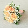 Curated for moments of lasting joy, this Oxford-inspired bouquet breathes refined charm and gentle celebration. Gently resting atop a lightly textured, pale beige linen surface, the rounded form features a lush profusion of peach and apricot roses-their petals unfolding in harmonious waves that catch the soft ambient light, recalling tranquil scenes along the Isis on a crisp afternoon. Interlaced amidst the roses are plentiful, airy clusters of baby's breath, whose tiny white blossoms create a mist-like effect, at once delicate and uplifting, while deep green leaves emerge in tasteful contrast, grounding the gentle colour palette. Each element is artfully gathered and bound with a coral-toned satin ribbon whose tactile richness evokes memories of formal balls at Oxford colleges. Adorning the ribbon are gleaming miniature pearls, spiraling down the handle with a subtle grace and hint of vintage luxury. The clean-cut stems peek below, evidence of fine, local florist care. Soft, even lighting ensures each detail-petal, pearl, and sprig-stands out in quiet celebration, making this bouquet equally suited for Oxford weddings, elegant anniversary dinners overlooking Magdalen Tower, or heartfelt gifts delivered to friends across Jericho and Headington. The arrangement embodies timeless romance, thoughtful design, and the gentle artistry that Springs from Oxford's floral tradition-a bouquet that becomes a cherished part of the day it graces.