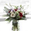 This radiant bouquet, crafted for the Oxford community, is an ode to harmony and subtle contrast. The deep crimson of velvety roses imparts drama and romance at the heart of the ensemble, surrounded by stately white gerberas whose petals fan outwards from dark, cocoa-hued centres. Gentle waves of soft, lavender-toned lisianthus infuse a hint of playfulness, their buds just beginning to open, echoing the anticipation and renewal that lingers across Oxford in springtime. Sprigs of fluffy white filler flowers nestle between the larger blooms, conjuring the image of cottony clouds floating above University Parks. Sprays of eucalyptus, with their round, silvery-green leaves, add sophisticated texture and a refreshing scent that mingles subtly with roses-a fragrance that evokes Oxford's leafy gardens after rain. Lush, sculpted greenery envelops the base, framing the bouquet like a living tapestry, while the crystal-clear vase allows every stem to be admired in water. Designed for moments of gratitude, heartfelt celebration, or thoughtful remembrance, this bouquet reflects the quiet confidence and vibrant life of Oxford, ideally suited for delivery to friends and loved ones throughout the city's picturesque neighbourhoods.