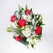 A hand-tied bouquet of red roses, pink-red carnations, white daisies and chrysanthemums, and airy gypsophila is captured in soft, natural light, looking as if it has just been set down on a kitchen table in an Oxford terrace near the Cowley Road. The roses are the first thing your eye finds: bold, velvety blooms in deep crimson, their petals unfurling in confident spirals. Around them, ruffled carnations in similar rich tones add volume and playful movement, their edges almost featherlike. Clusters of snow-white daisies and tiny white chrysanthemum heads brighten the whole composition, their golden centres and daisy-petal rays giving the bouquet a fresh, morning-like radiance. Misty sprigs of baby's breath are threaded through the arrangement, creating a soft, cloudlike veil that makes each red petal seem to glow a little brighter. Tall, slender eucalyptus stems and glossy tropical greens frame the flowers, their cool silvery and deep green shades bringing a modern, slightly architectural feel, like foliage seen in University Parks after rain. The bouquet is compact yet breathing with space, each bloom clearly visible and thoughtfully placed. It feels joyful and welcoming, ideal for a birthday tea in Jericho, a congratulations gift delivered across Oxford, or simply to brighten a favourite reading nook at home. The colours are vivid but harmonious, the textures inviting to the touch, and the overall mood is one of cheerful celebration and heartfelt affection, as though the florist has captured an uplifting moment and tied it carefully with ribbon.