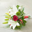 Set against a neutral, woven fabric that looks like softly lit ivory linen, this bouquet is arranged on a gentle diagonal, as if just laid down on a table in a classic Oxford townhouse. Large white oriental lilies stretch across the composition, some fully open with wide, satin-smooth petals edged in the faintest ripple, others still closed as sleek green buds that hint at days of beauty to come. Their throats show subtle freckles of russet red, drawing the eye inward. At the visual centre, a single deep red rose glows like a jewel, its petals wrapped closely in a perfect spiral that speaks of enduring love and quiet devotion, the kind of bloom you might carry for a ceremony in one of Oxford's historic colleges or a wedding at the Sheldonian. Between the lilies and rose, two plush 'Green Trick' dianthus sit like tiny moss cushions, their tufted spheres adding tactile interest and a fresh, contemporary twist. Fine sprays of white baby's breath thread through the bouquet, airy and cloud-like, softening the strong shapes, while clusters of vivid red hypericum berries punctuate the greenery with glossy, berry-bright accents. Surrounding everything is an abundance of foliage: broad, deep-green leaves provide structure and depth, while slender, grass-like stems arc outward, giving the bouquet a sense of movement, as if stirred by a light breeze along the Cherwell. The stems are tightly gathered and wrapped with a wide band of luxurious red satin ribbon, its sheen catching the light and trailing neatly towards the lower right corner. The whole design feels refined yet heartfelt, ideal for winter weddings, anniversary deliveries in Summertown, or romantic surprises anywhere in Oxford.