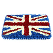 A bold Union Jack floral tribute dominates the image, its rectangular form laid out neatly against a pure white background so that every detail of the design stands out. The entire flag is built from masses of small, cushion-like blooms arranged so closely that no gaps of foliage or foam are visible, giving the piece a smooth, quilted feel. Deep blue flowers form the solid backdrop, covering the whole base like a midnight-coloured blanket. On top, pristine white blooms mark out the central horizontal and vertical bars of St George's Cross, their petals fresh and slightly ruffled, catching soft light as though placed near a window in an Oxford church or funeral home. Striking bands of rich red carnations sweep diagonally across the composition to depict St Patrick's Cross, each red stripe sharply bordered with narrow lines of white flowers so the pattern remains crisp and unmistakably British. The flowers are gently graduated in height towards the middle, creating a raised, pillow-like surface that adds dimension and gravitas. Along the bottom, a pleated blue ribbon, satin in appearance, runs the full width of the tribute, giving a smart, tailored edge to the arrangement. This floral union flag is both patriotic and deeply personal, equally suited for resting atop a coffin or standing as a central display at a memorial for someone who cherished their British identity and perhaps held close connections to Oxford's communities around Headington, East Oxford, or the city centre. It conveys honour, gratitude, and lasting respect through carefully chosen colour and craftsmanship.