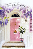 An Oxford townhouse doorway is shown at the most hopeful moment of the day, when light is soft and the future feels wide open. The door itself is painted a calm, pastel pink, with its smooth panels catching the muted glow that you might see on a spring evening near Christ Church Meadow. Surrounding the frame, long tendrils of wisteria cascade in curtains of lavender, lilac and soft purple, the blossoms hanging in delicate clusters that almost brush the top of the step. Their presence suggests a sweet, floral perfume drifting through the air, mingling with the coolness of the shaded wall. Against the whitewashed facade, the colours become even more luminous, creating a dreamy contrast between the creamy background and the pastel blooms. Placed carefully at the threshold is a grey metal bucket, slightly rustic in finish, overflowing with white and ivory roses. The roses are plush and full, with layered petals that look as soft as silk, accompanied by sprigs of fresh, leafy greenery that frame the blooms and add a gentle lift of texture. Around the bucket's base, a soft pink ribbon is tied into a simple bow, its colour echoing the door and drawing the eye downward in a satisfying visual rhythm. The shadows from the wisteria create dappled patterns over the step, giving the whole scene depth and quiet movement. Everything in the composition-from the trailing flowers to the artfully placed bouquet-suggests a thoughtful housewarming gift in Oxford, a floral way of easing the transition into a new home and infusing the entrance with warmth, grace and heartfelt welcome.
