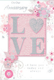 This anniversary card captures the feeling of enduring romance in a soft palette of pastel pinks and silvery greys, reminiscent of blossom trees in Oxford on a calm spring day. The focal point is the word LOVE, set proudly in the centre in raised, soft glitter that gives the letters a velvety, tactile finish. The letter O is replaced by a shimmering silver heart, subtly textured so it gleams when the light touches it, much like reflected sunshine on the River Cherwell near University Parks. Surrounding this centrepiece, delicate blooms in blush and mauve unfold with a watercolour-like softness, their petals and leaves drawn in fine, flowing lines that evoke the care of a florist arranging romantic stems on a Broad Street shop counter. Tiny flourishes-petals, gentle swirls, and small, almost secret butterflies-scatter through the design, adding an airy sense of movement and whimsy. These flourishes call to mind the light rustle of flowers in a bouquet carried through the lanes of Jericho. The soft pink background keeps the composition warm and intimate, while touches of silver detailing provide a refined sparkle. Phrases such as On Our Anniversary and I love you today and always appear in graceful, understated script, their curves echoing the swirling vines around them. The overall effect is that of a cherished keepsake, the kind of card chosen to sit beside freshly delivered anniversary flowers in an Oxford home, quietly marking years of shared memories, trust, and affection with a design that feels both tender and timeless.